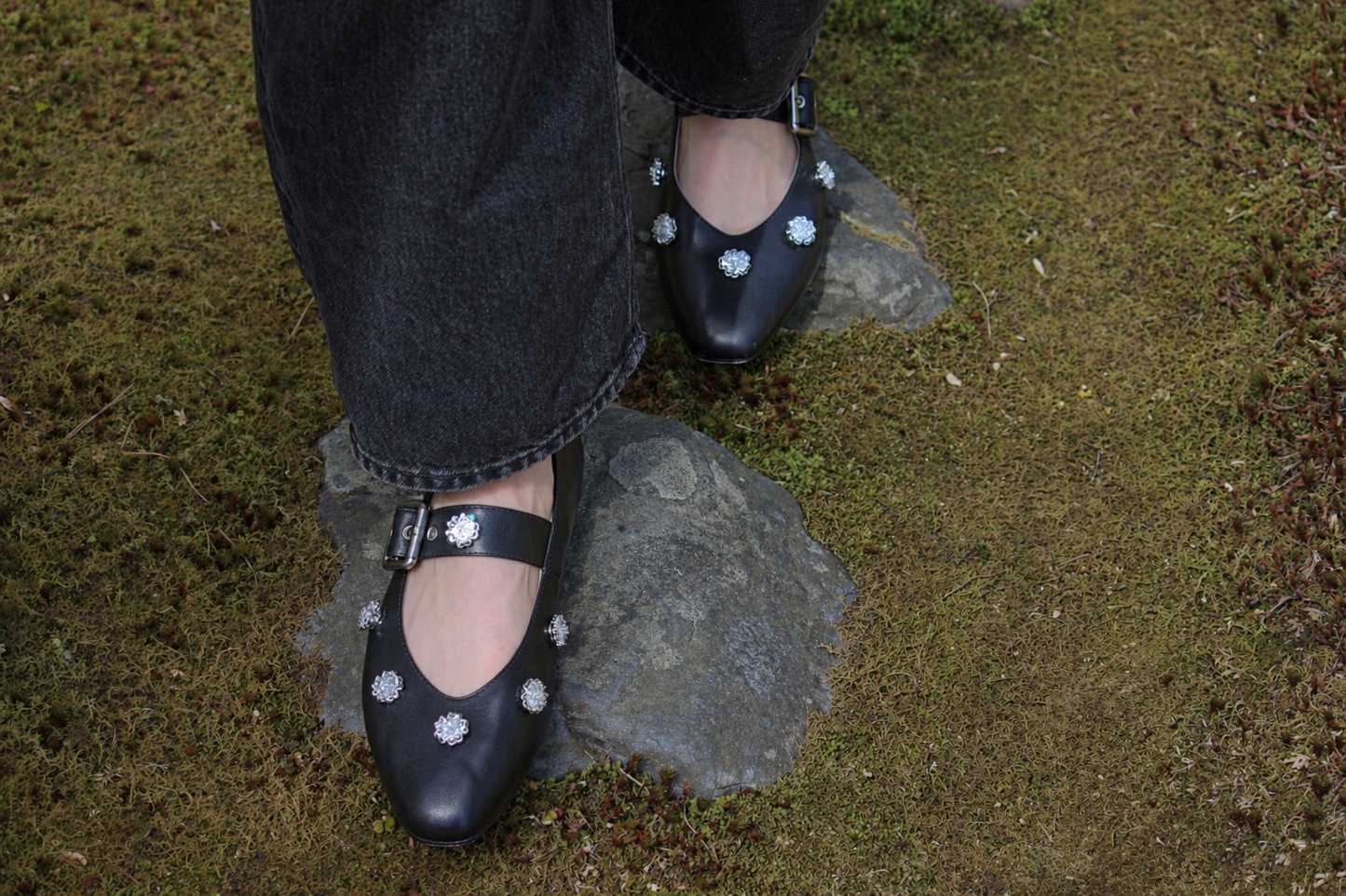 Black shoes with white floral patterns on a stone surface #silver