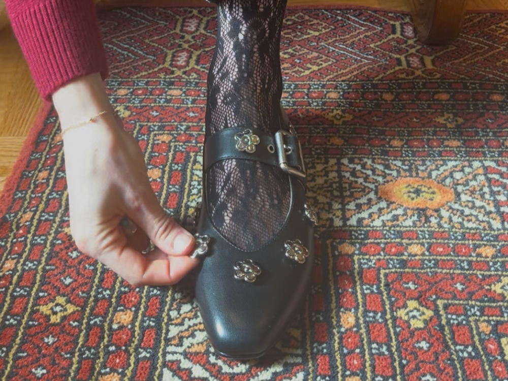 Woman placing a shoe charm on a pair of leather Mary Janes